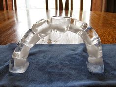 an ice sculpture sitting on top of a blue cloth in front of a wooden table