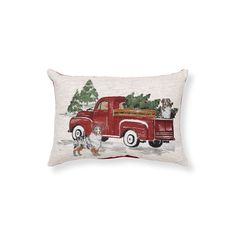 a red truck filled with christmas trees sitting on top of a white floor pillow next to a chicken