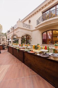 an outdoor buffet with lots of food on the table and in front of a building