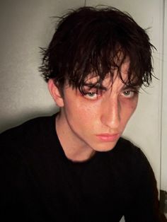 a young man with black hair is staring at the camera