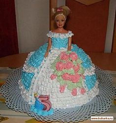 a cake made to look like a barbie doll with flowers on the skirt and dress