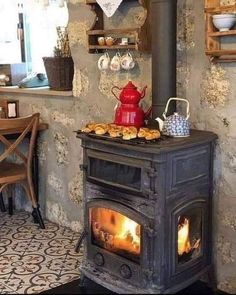 there is a wood stove in the kitchen with pastries on the table next to it