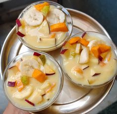 three desserts with fruit are on a silver platter, ready to be eaten