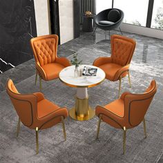 four orange chairs around a white table in a room with gray carpet and black walls