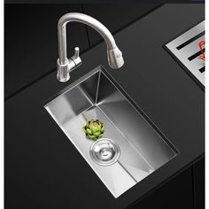 a stainless steel kitchen sink with a faucet over it and an artichoke on the counter