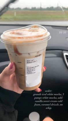 a woman holding up a cup of iced coffee