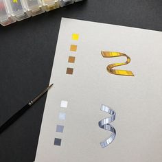 the letter s is made out of metallic foil and has tape on top of it