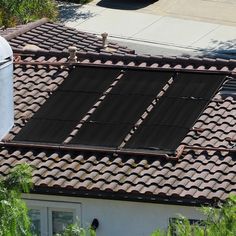 the roof of a house with a solar panel on it's shingled tiles