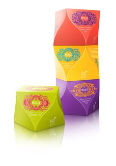 three colorful boxes with designs on them sitting next to each other in front of a white background