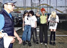 a group of young people standing on top of a wooden floor next to each other