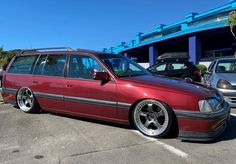 a red station wagon parked in a parking lot