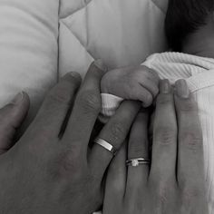 a man and woman holding a baby in their arms while they both hold each other's hands