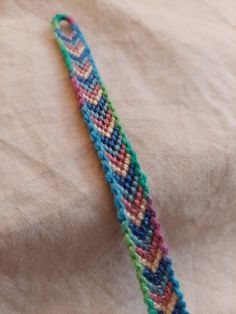 a colorful bracelet is laying on top of a white cloth