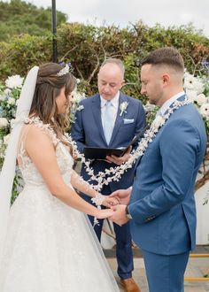 a bride and groom holding hands during their wedding ceremony