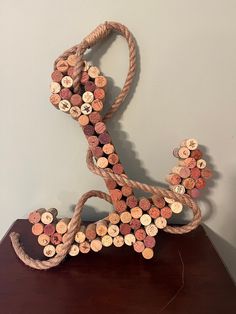 a sculpture made out of wine corks on top of a wooden table next to a wall