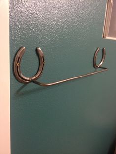 a pair of scissors hanging on the side of a green wall in front of a door