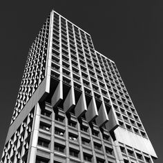 a very tall building with lots of windows on it's sides and the sky in the background