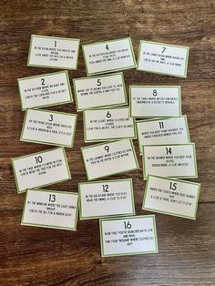 some green and white cards with numbers in them on a wooden table next to a cup