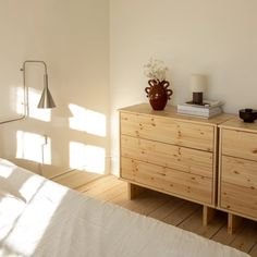 a bedroom with white walls and wooden furniture