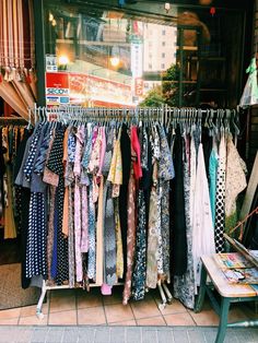 clothes are hanging up in front of a store