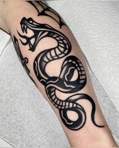 a black and white snake tattoo on the arm