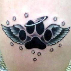 the back of a woman's stomach with an angel wing and paw prints on it