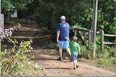 a man and child walking down a dirt path