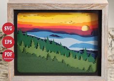 a wooden frame with an image of mountains and trees on it