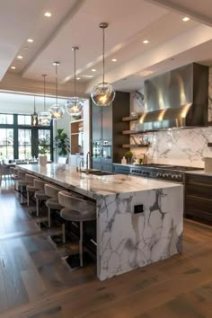 a large kitchen with marble counter tops and wooden floors