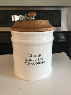 a cookie jar sitting on top of a counter next to an oven with the words life is short eat the cookies