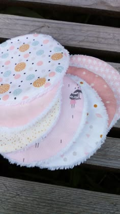 five baby hats sitting on top of a wooden bench