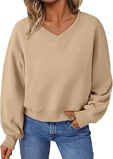 a woman wearing a tan sweater and jeans