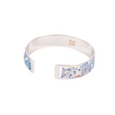 This silver-plated brass bracelet features a floral motif painted in watercolor, with delicate flowers in shades of blue blooming against a white background. The watercolor paint gives the flowers a soft, blurred appearance, as if they had been delicately dipped in water, creating a dreamy, artistic effect. The bracelet itself has an open design, allowing an easy and comfortable fit on the wrist. The contrast between the metallic shine of the silver-plated brass and the delicacy of the watercolo Liberty Bracelet, Formal Accessories, Brass Bracelet, Delicate Flowers, Open Design, Watercolor Paint, Dressy Outfits, Delicate Flower, Jewelry Inspo