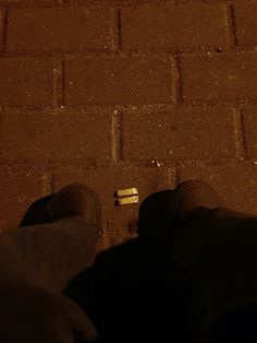 a person standing on the sidewalk with their feet up next to an object in the ground