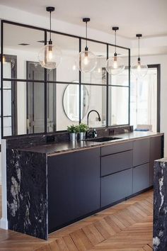 a kitchen with marble counter tops and black cabinets