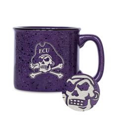 a purple coffee mug with a skull and crossbones on the side, next to a