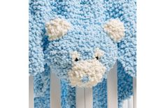 a crocheted blue bear is hanging on the side of a white radiator