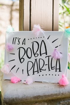 a sign that says it's a booa party with pom - poms