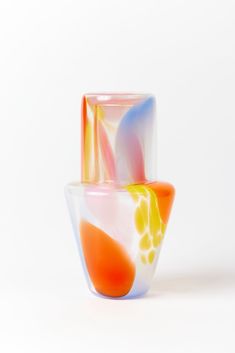 two colorful glass vases sitting side by side on top of each other in front of a white background