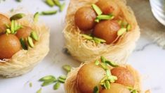 three small baskets filled with food sitting on top of a white tablecloth covered counter