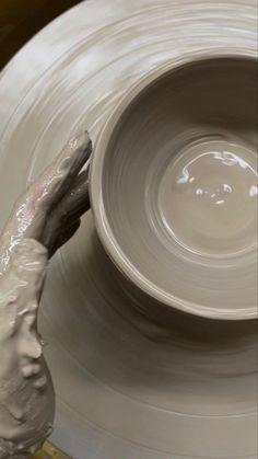 a person is making a bowl on a potter's wheel