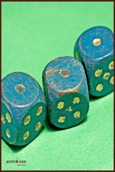 three blue dices with gold spots sitting on top of each other in front of a green background