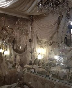 a room filled with lots of white furniture and chandeliers