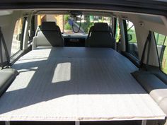 the interior of a vehicle with its cargo area folded up to allow extra space for two people