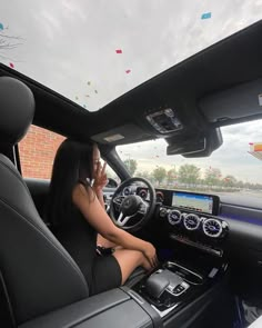 a woman sitting in the driver's seat of a car