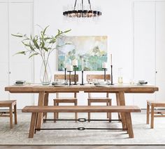 a dining room table and bench with candles on it