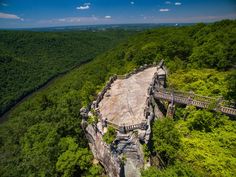 an aerial view of a bridge in the middle of a forest