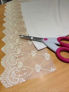 two pairs of pink scissors sitting on top of a lace covered table cloth next to white doily