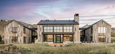 a large wooden house sitting on top of a lush green field