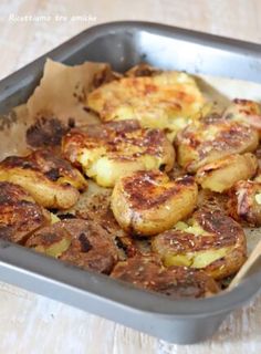 a pan filled with cooked potatoes on top of a wooden table